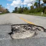 Damaged,American,Road,Surface,With,Deep,Pothole.,Ruined,Street,In