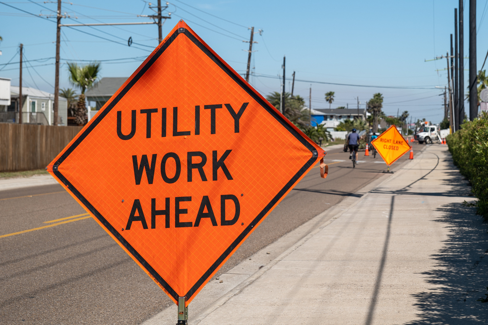 Utility,Work,Ahead,Sign,On,Sidewalk,Next,To,Street,Warns